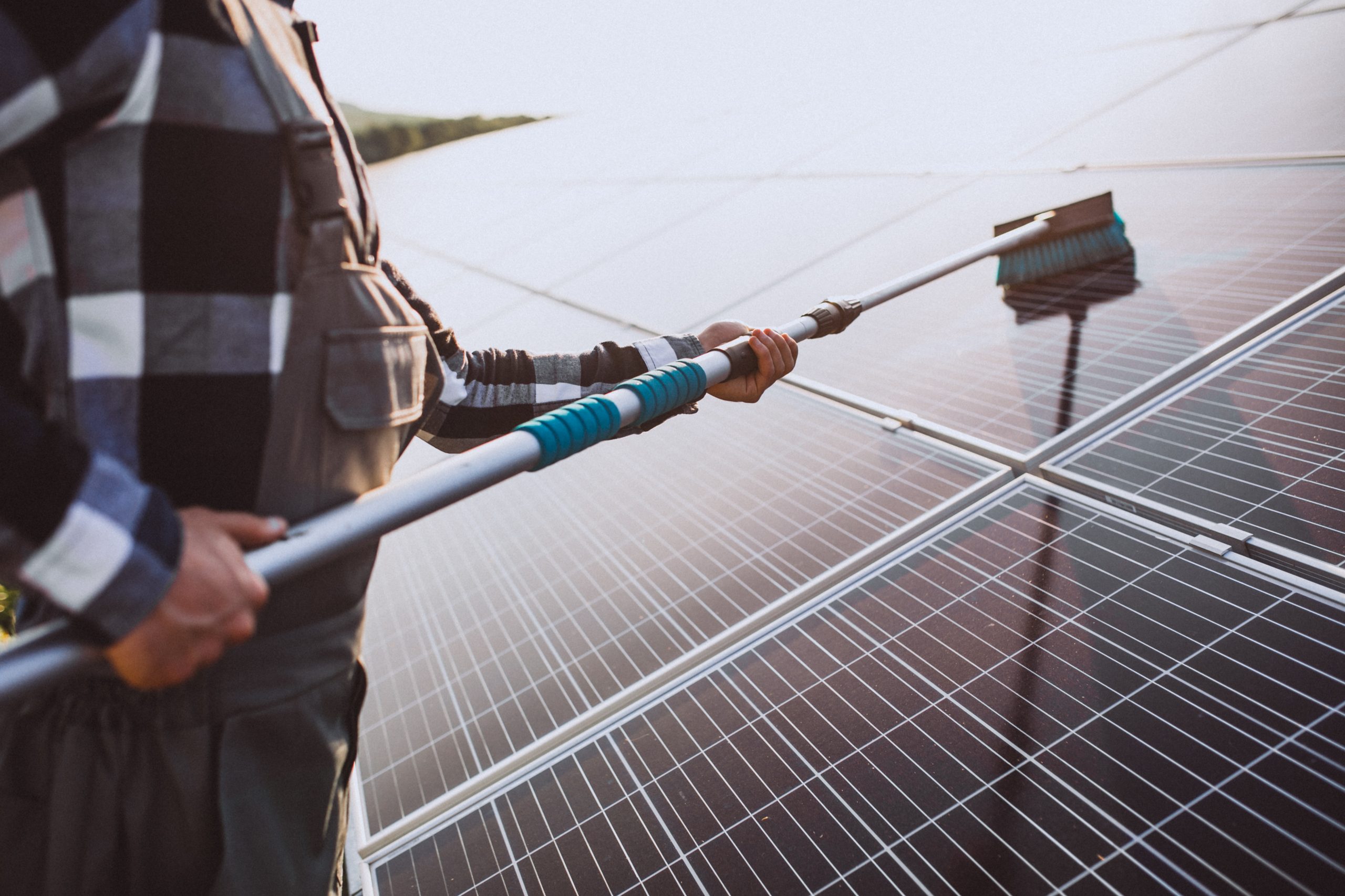 Person Maintaing Solar Panels Solar Panel Maintenance in London Surrey Solar Solutions